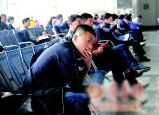 在車(chē)站內(nèi),一名旅客正在吸煙