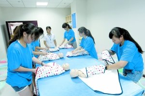 昨日，學生們正在進行給嬰兒穿衣服的訓練。