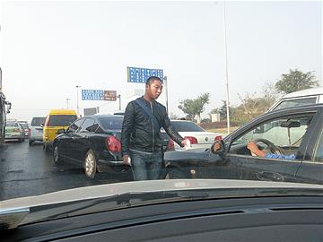 車流中插廣告者屢禁不止 名片或致車門銹蝕 車流中插廣告者屢禁不止 名片或致車門銹蝕