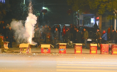 上圖：昨晚7點(diǎn)49分，在漢口建設(shè)大道802號(hào)長(zhǎng)江委酒寶蕩小區(qū)門前的人行橫道上，有人大肆燃放煙花爆竹，硝煙彌漫，空氣污染。 記者金思柳 攝