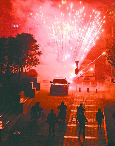 左圖：昨晚8點(diǎn)09分，在武昌徐東大街東段的湖北銀行門前，有人大肆燃放煙花爆竹，不少行人望而卻步。 記者金思柳 攝